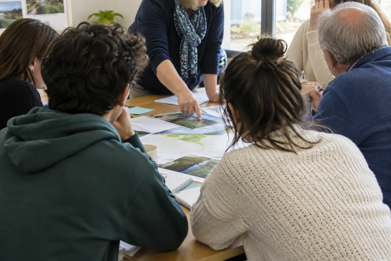 Des bénévoles de plusieurs générations échangent autour d’une table dans une salle associative.